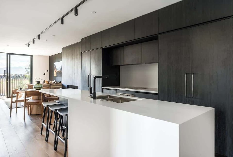 Luxury modern kitchen, Clubhouse Lane apartments, Jacks Point Golf Course. Stone benchtops, high-end appliances, breakfast bar, panoramic Remarkables & Lake Tewa views. Queenstown golf & ski retreat.