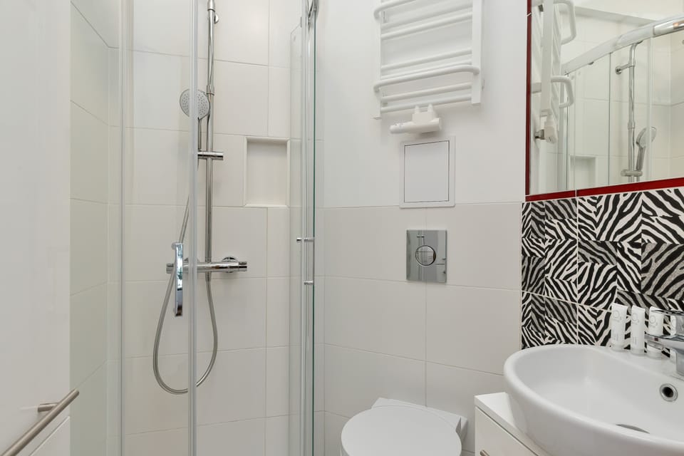 A bathroom with a glass shower and modern fixtures. Clean and practical design.