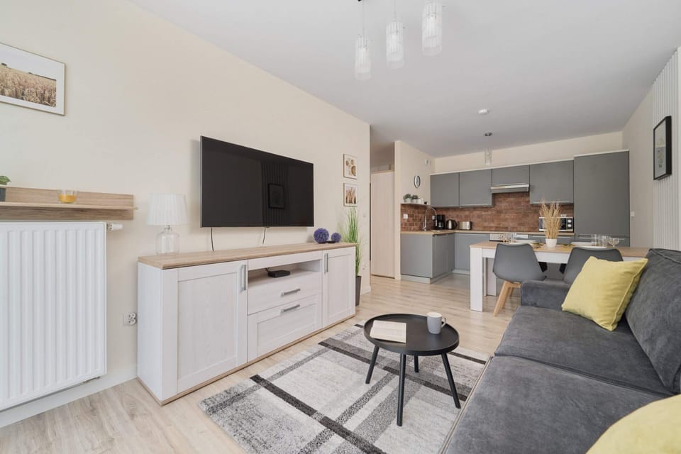 Open-plan living and kitchen area featuring a minimalist design and ample seating.

