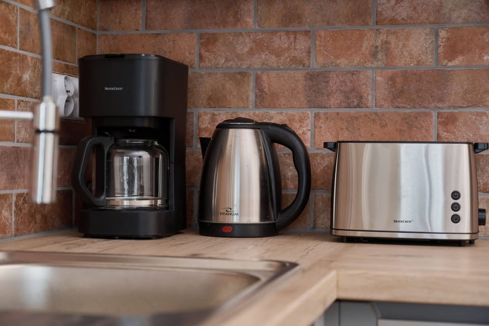 Coffee and tea station equipped with a coffee maker, kettle, and toaster.

