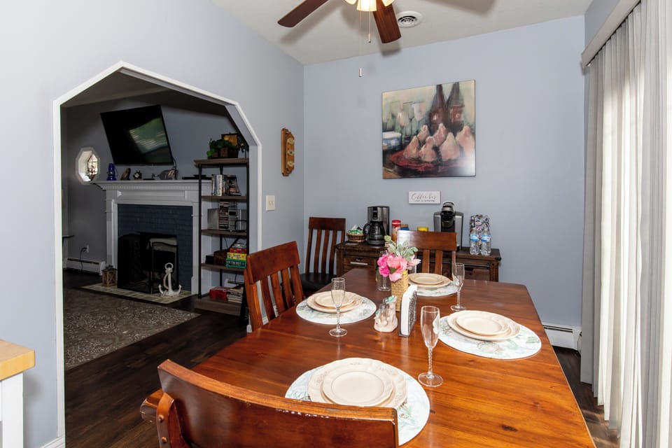 Gather with loved ones around this warm dining table, beautifully set for your next meal. The cozy fireplace and charming archway create an inviting space where your vacation memories are made.