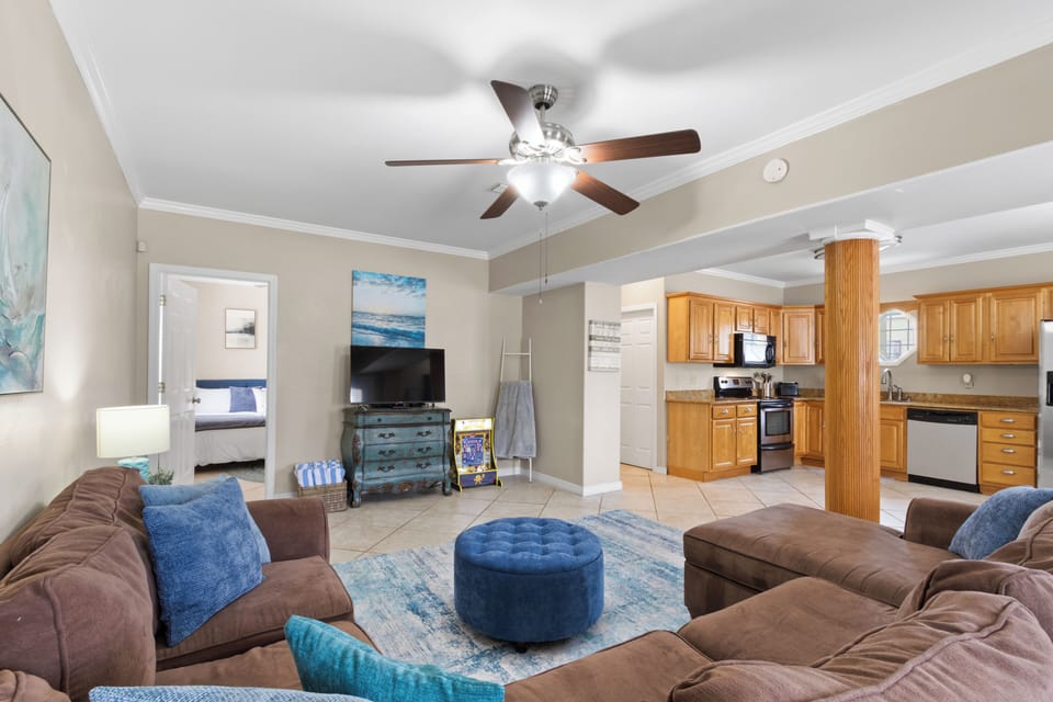 Open-concept lounge + full kitchen, cozy sectional & coastal vibes