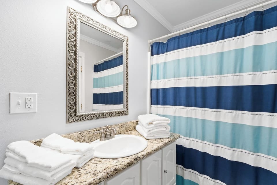 Bright bath with granite vanity, fresh towels, and coastal accents