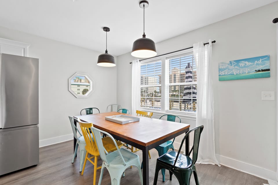 Sunny dining nook with colorful chairs and marina-view windows