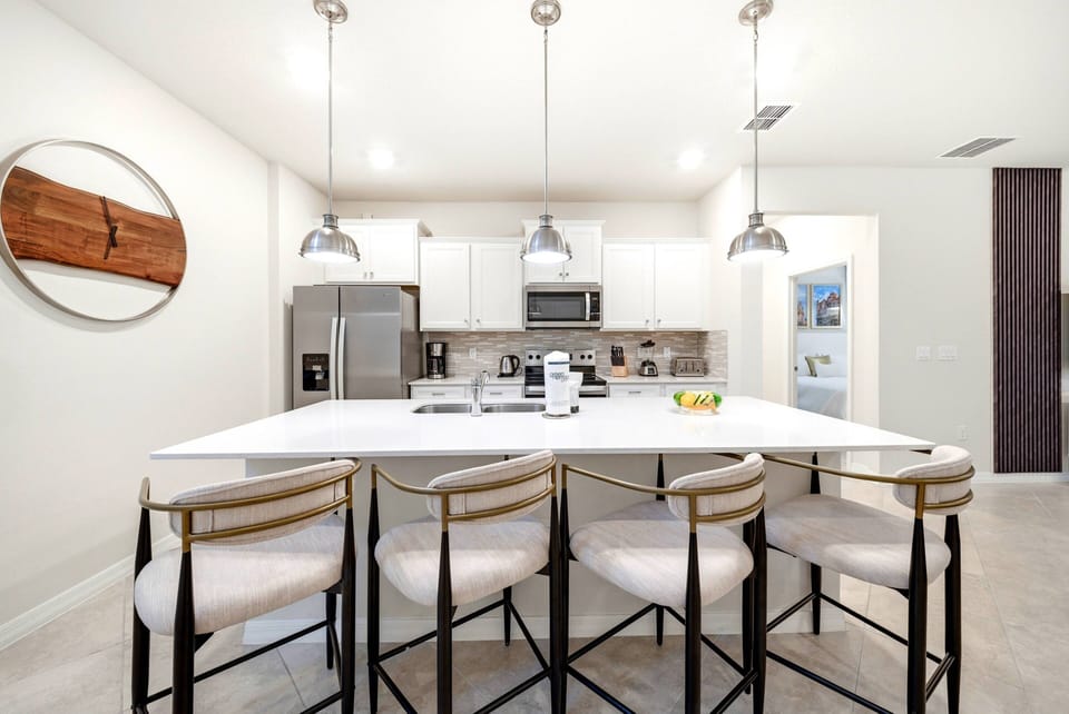 Welcome to this bright and airy kitchen, featuring a spacious island with stylish bar seating for casual meals and conversation. Enjoy modern appliances and soft lighting that create a warm and inviting atmosphere.