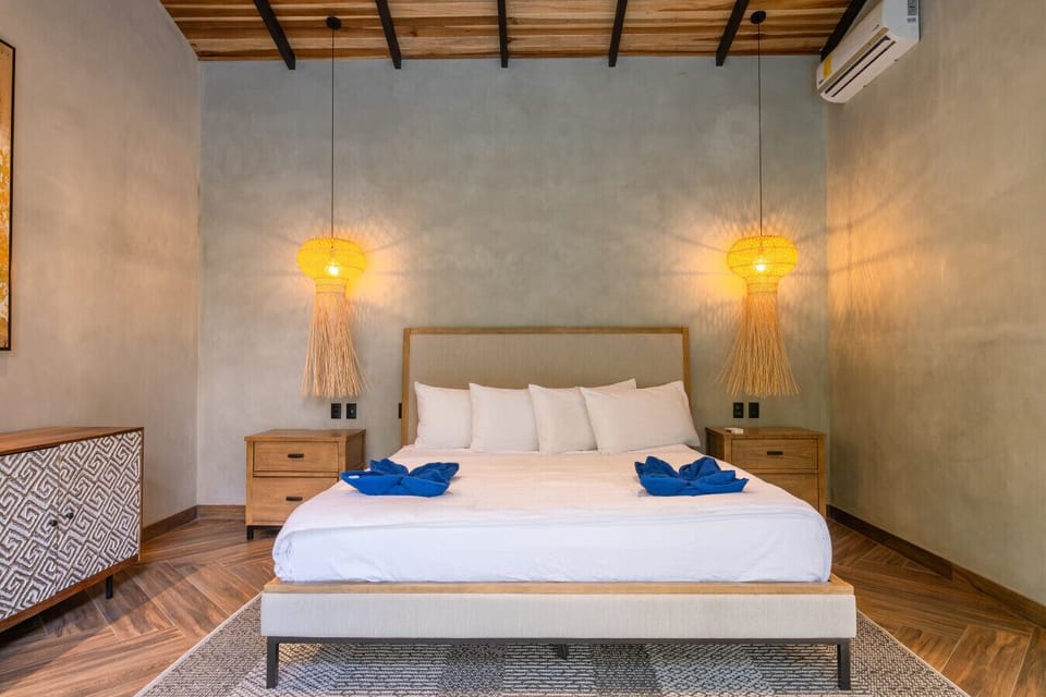 Spacious bedroom with AC and king bed, offering a cool and comfortable retreat in the tropical hills of Punta Uva.