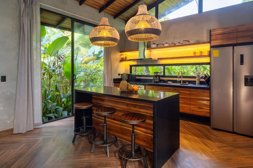 Modern kitchen with island and garden views, fully equipped for a relaxed stay near Punta Uva beach.