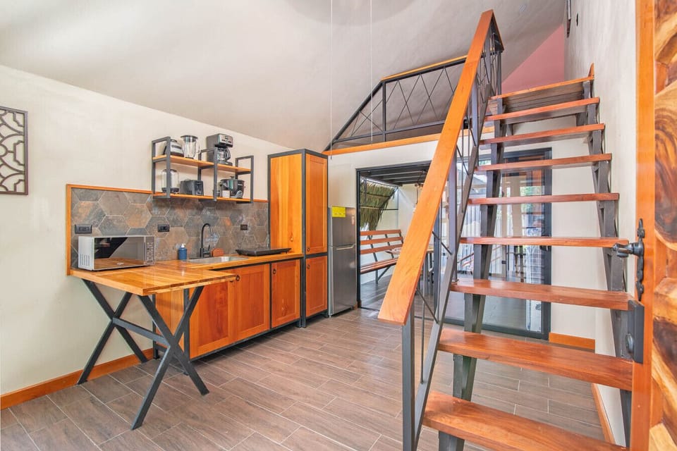 Modern villa kitchen with view of staircase leading to second floor in Caribbean Costa Rica