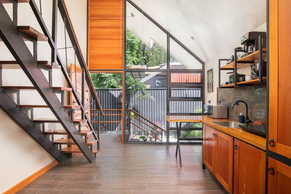 Open kitchen connecting to main entrance, dining area and second floor stairs in tropical villa
