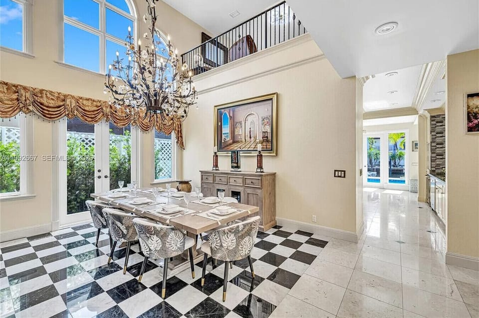 Formal dining room featuring seating for eight, a statement chandelier and bright windows perfect for entertaining