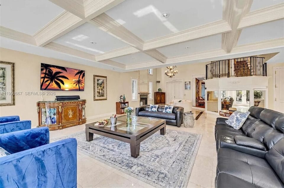 Spacious living room with ample leather seating, a flat-screen TV and large coffee table for gatherings