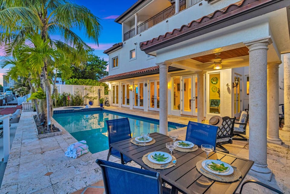 Resort-style pool area featuring a shaded dining space and ample waterfront loungers ideal for families