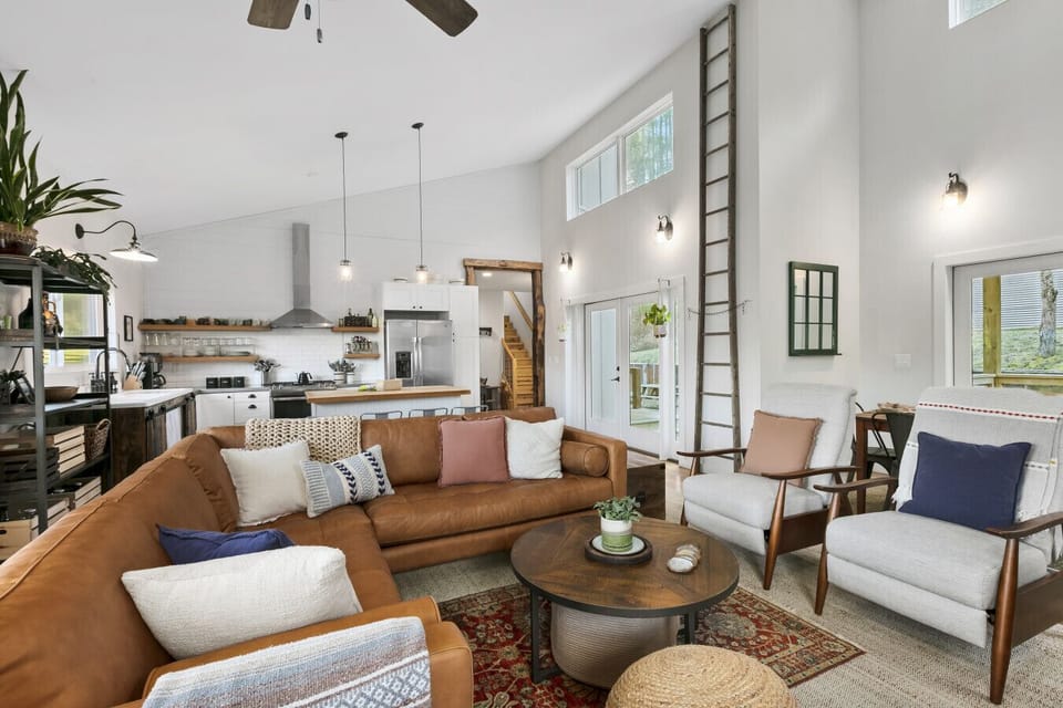 Soaring ceilings, plush seating, and layered textiles make this home feel airy, warm, and inviting.