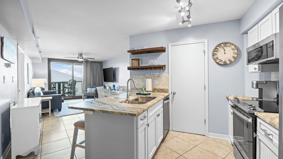Fully equipped kitchen with breakfast bar and open-concept living space.