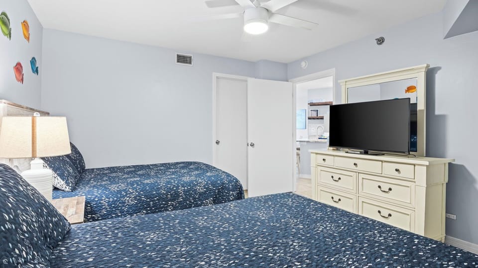 Spacious bedroom with two beds, a TV, and plenty of room to unwind.