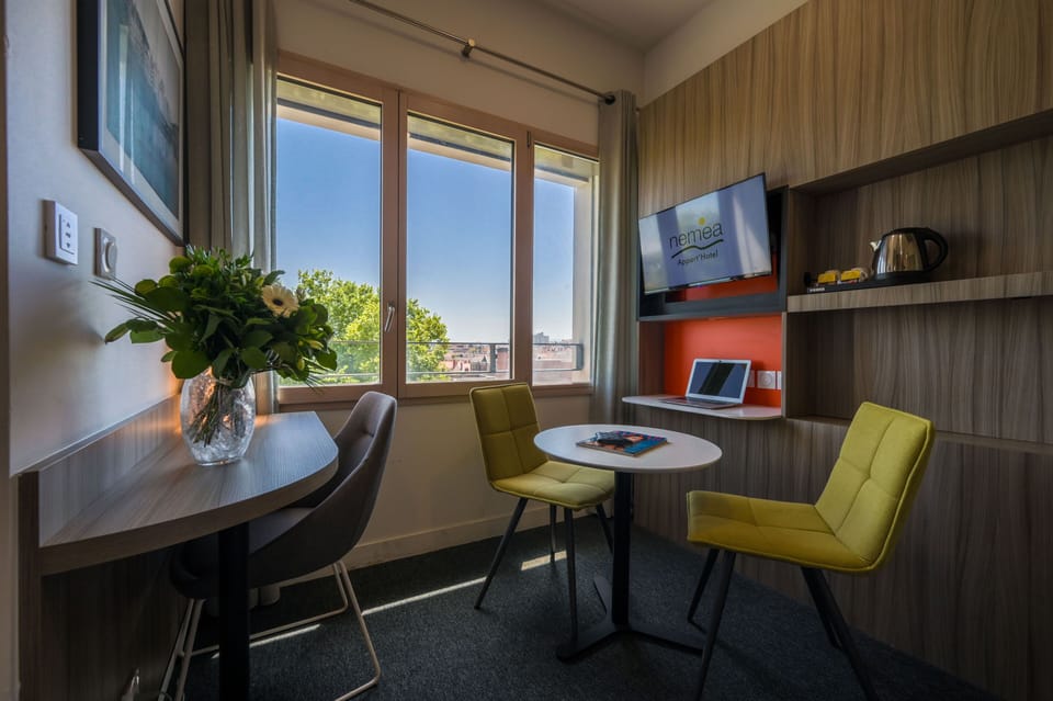 Workspace and dining corner set by the window, ideal for business or leisure stays.