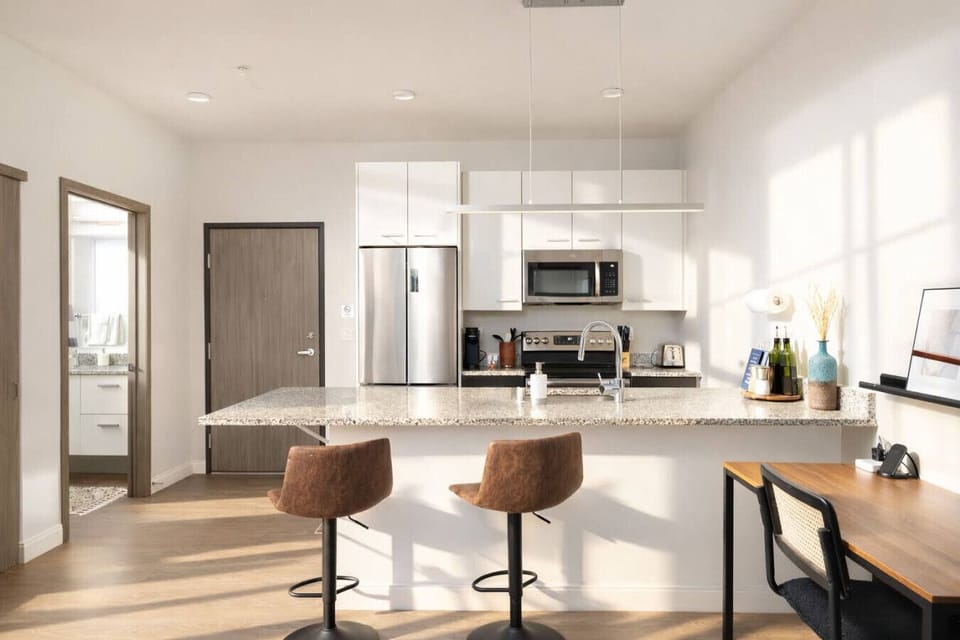 Chef’s kitchen featuring sleek granite countertops, stainless steel appliances, and a spacious island for morning coffee