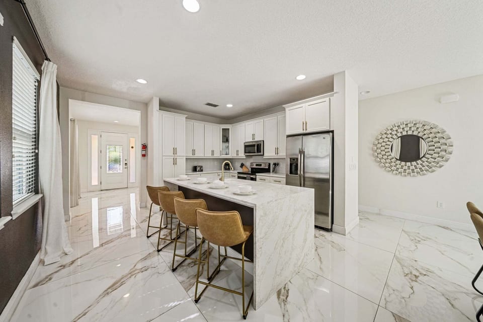 Gather around a large kitchen island w/ bar seating & sleek finishes for easy meals together