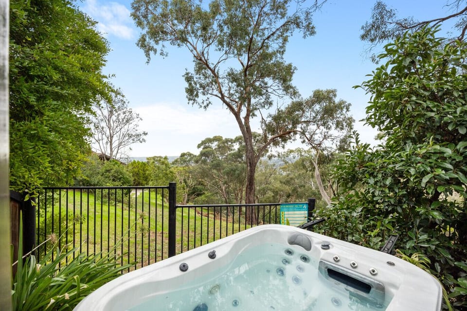 Soak in the private spa while taking in serene, elevated views of lush greenery and treetops.