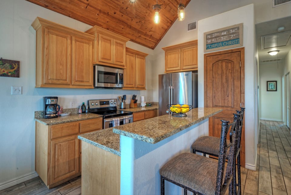 Cook, snack, and gather—full kitchen with granite breakfast bar seating. (Cole's Cabin)