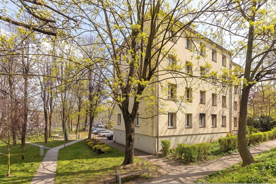 Peaceful exterior view of the building surrounded by greenery and mature trees.