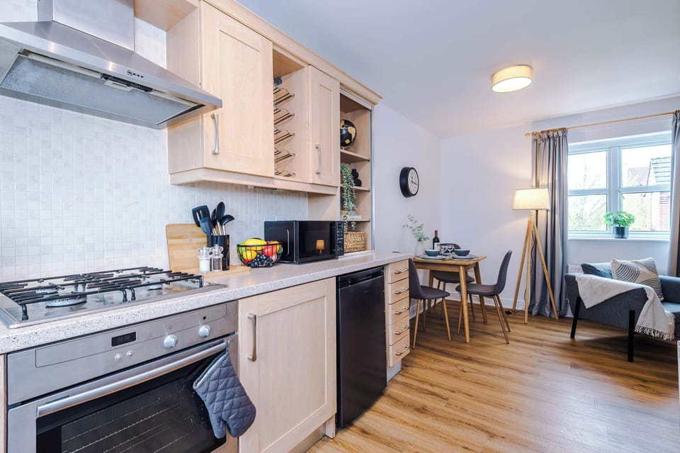Contemporary kitchen with oven, stovetop, fridge, microwave, washer, and kettle. Clean design and cozy ambiance for easy living.