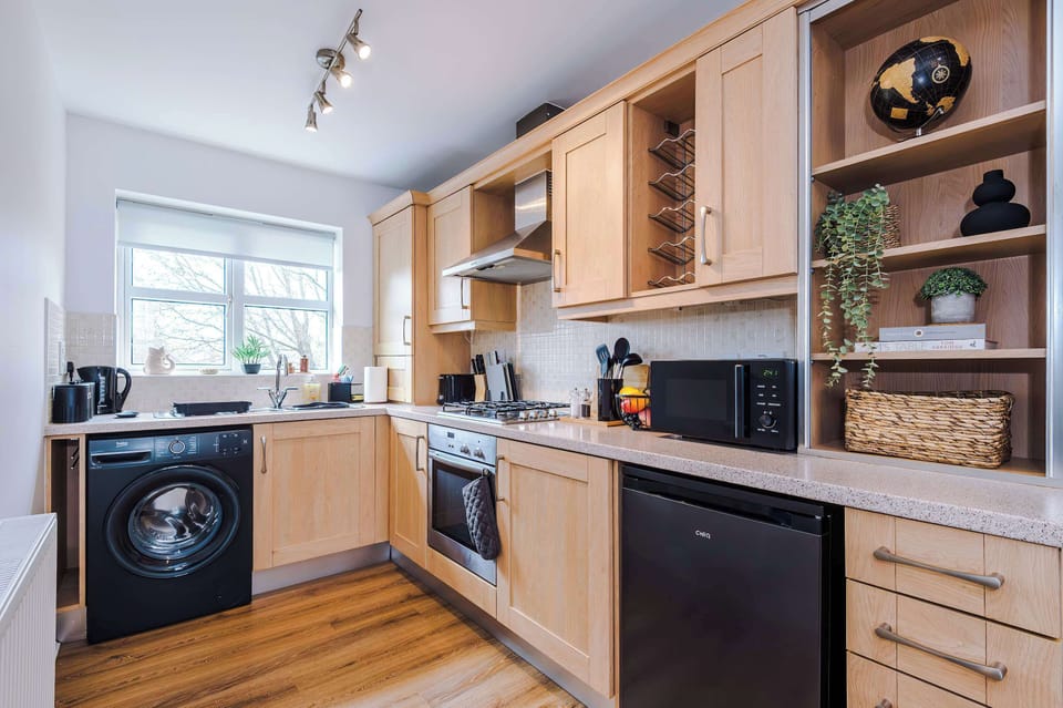 Fully equipped kitchen featuring modern appliances, wooden floors, and natural light. Ideal for guests who enjoy home comforts.