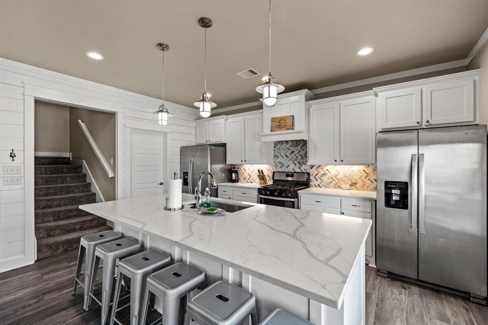 Kitchen island with bar seating and pendant lighting, ideal for entertaining in Crystal Beach vacation rental