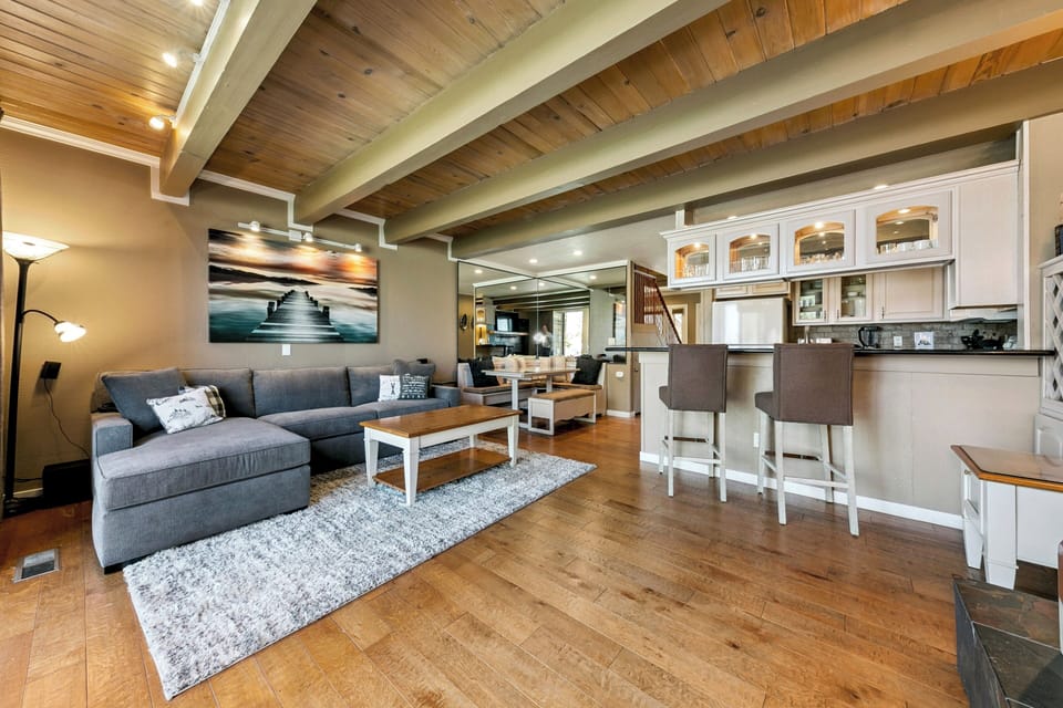 Picture yourself unwinding on the plush sofa under stunning wood-beam ceilings, enjoying the open flow of your inviting living and kitchen space.