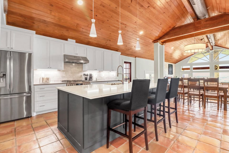 Your gourmet kitchen awaits with a spacious island, gleaming countertops, and soaring wood ceilings that create the perfect gathering space.