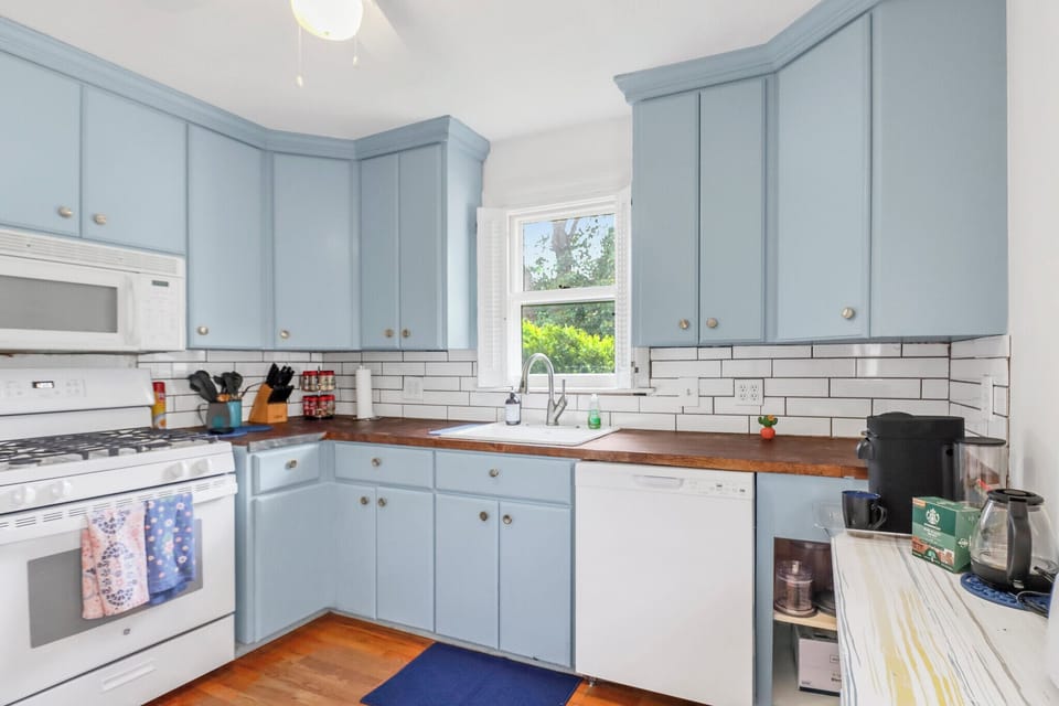 Bright kitchen features soft blue cabinets and modern appliances