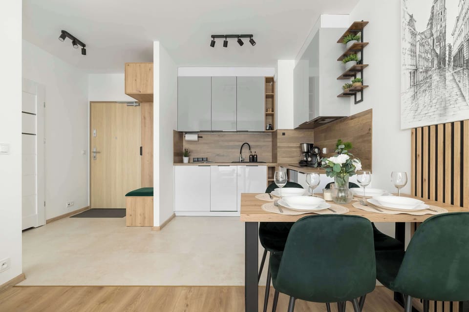 The kitchenette corner features a compact dining setup and modern art on the wall, maximizing the use of space.