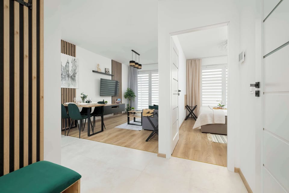 A perspective from the hallway towards the living room illustrates the bright and airy flow of the entire apartment.