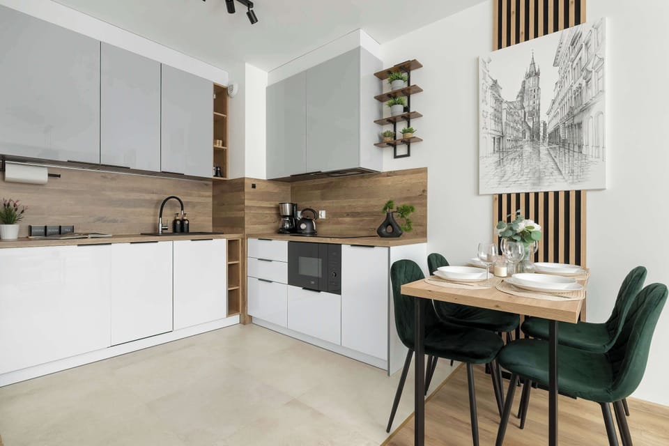 This shot emphasizes the sleek kitchenette line with white fronts, wooden finishes, and integrated LED lighting.