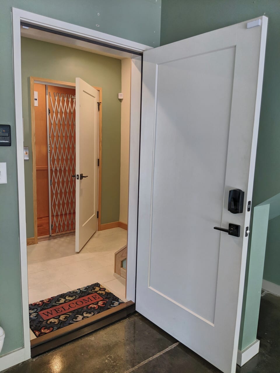 Elevator door on the other side of entry door from the garage