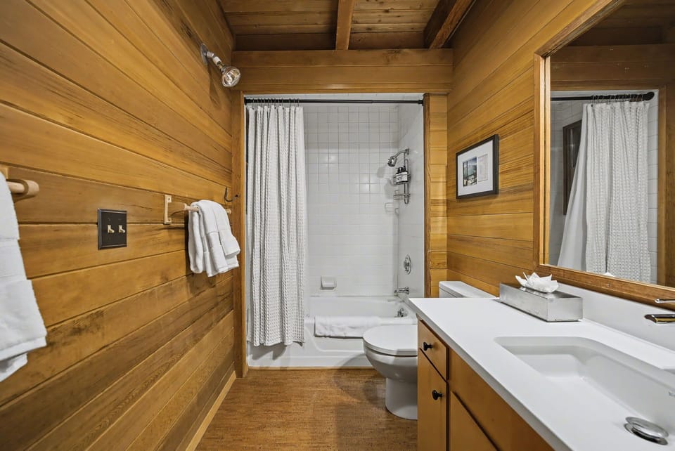 Warm woodland bathroom featuring clean modern tub & shower combo.