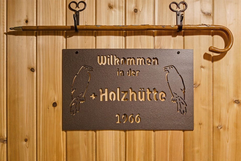 Authentic Holzhütte welcome sign celebrating timeless alpine cabin heritage since 1966.