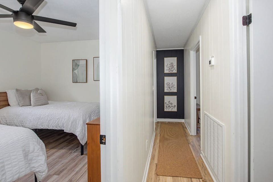 Your restful bedroom opens to a bright hallway with coastal artwork, creating a seamless flow throughout your home away from home.