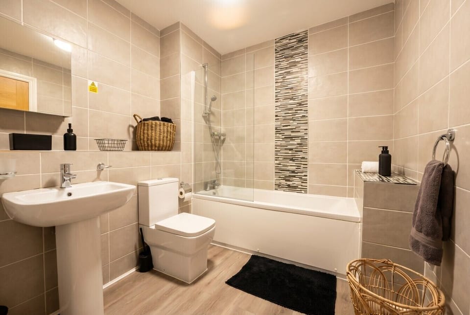 Full bathroom with bath, overhead shower and thoughtful styling throughout.