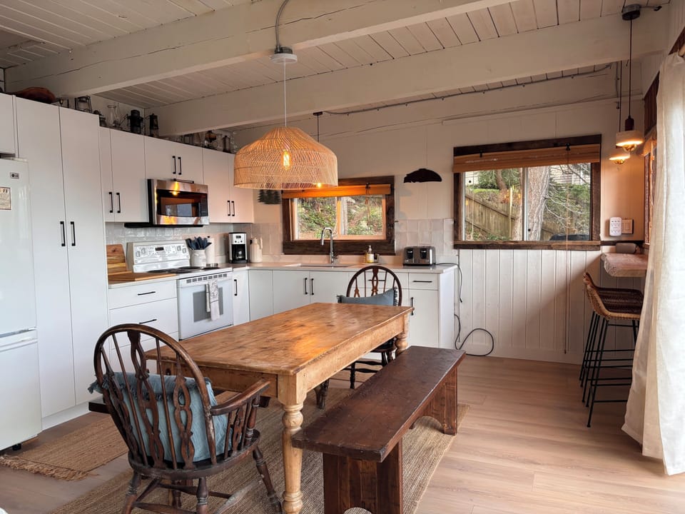 Large open kitchen with dining table and coffee bar by the windows. 