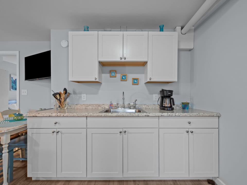 Your bright kitchen features granite counters, white cabinets, and everything you need for morning coffee or preparing meals.