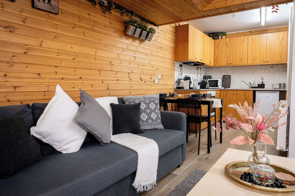 Bright and welcoming open-plan living, dining, and kitchen area, with a comfortable sofa and dining table, creating the perfect space to unwind, cook, and relax after a day of exploring.