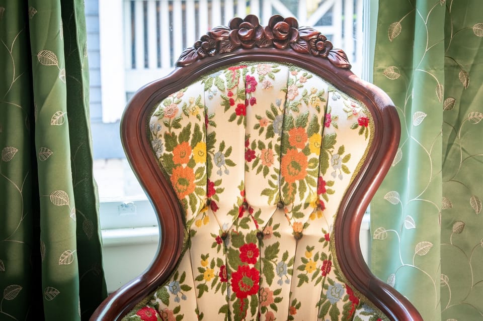Add a little charm to your day with this cozy vintage accent chair. The floral pattern and carved wood frame give it a warm, timeless feel.
