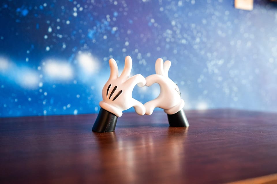 Decorative hands forming a heart shape against a starry blue background