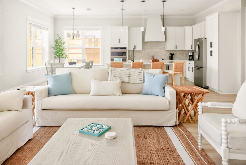Spacious living room with plenty of seating, a smart TV, and coastal decor—all opening seamlessly to the pool area 🛋️