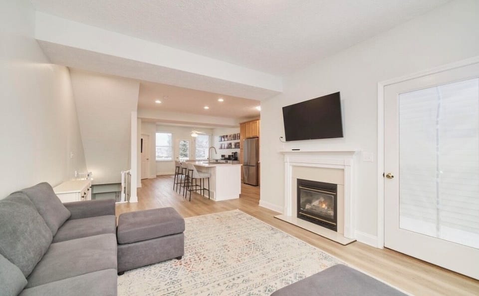 Living room with fire placed and outdoor patio facing a pond