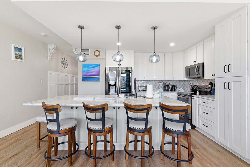 This beach stay features a bright, modern kitchen with a large island, bar seating, and updated appliances. Perfect for cooking, gathering, and enjoying relaxed coastal living after a day at the beach.