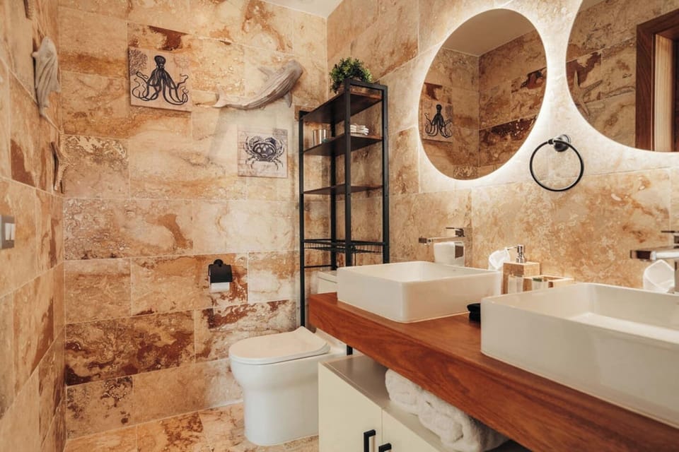 Bathroom 1 features a double vanity, warm stone finishes, and plenty of storage.