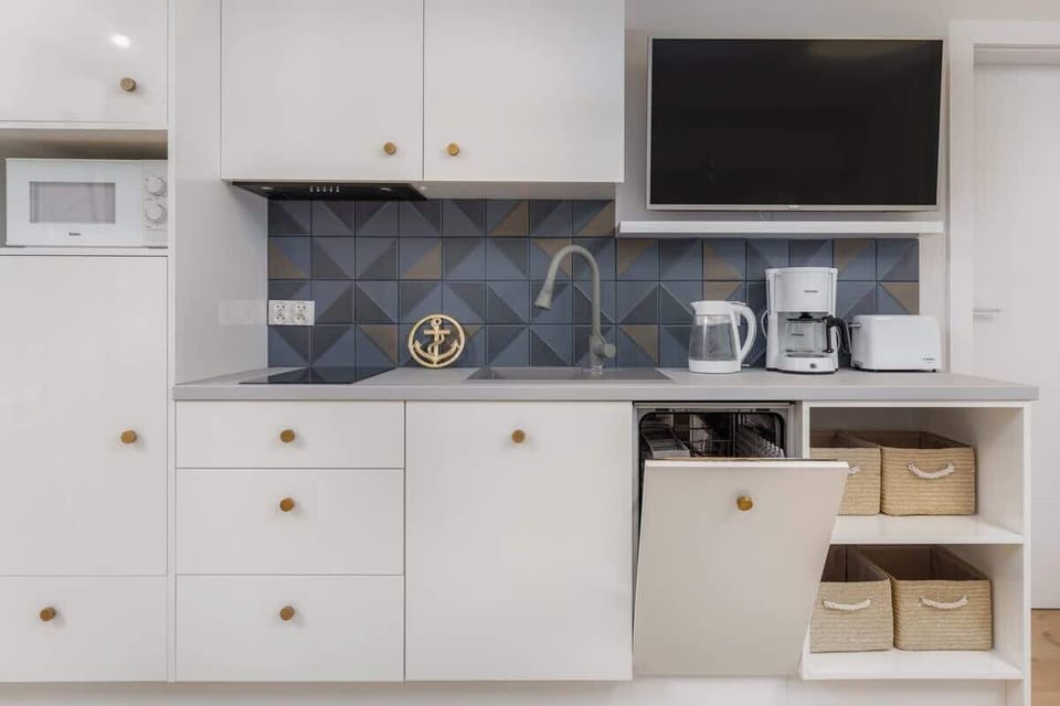 A close-up of a kitchen corner showcasing well-organized cabinets, a microwave, and essential cooking tools. Perfect for culinary enthusiasts.