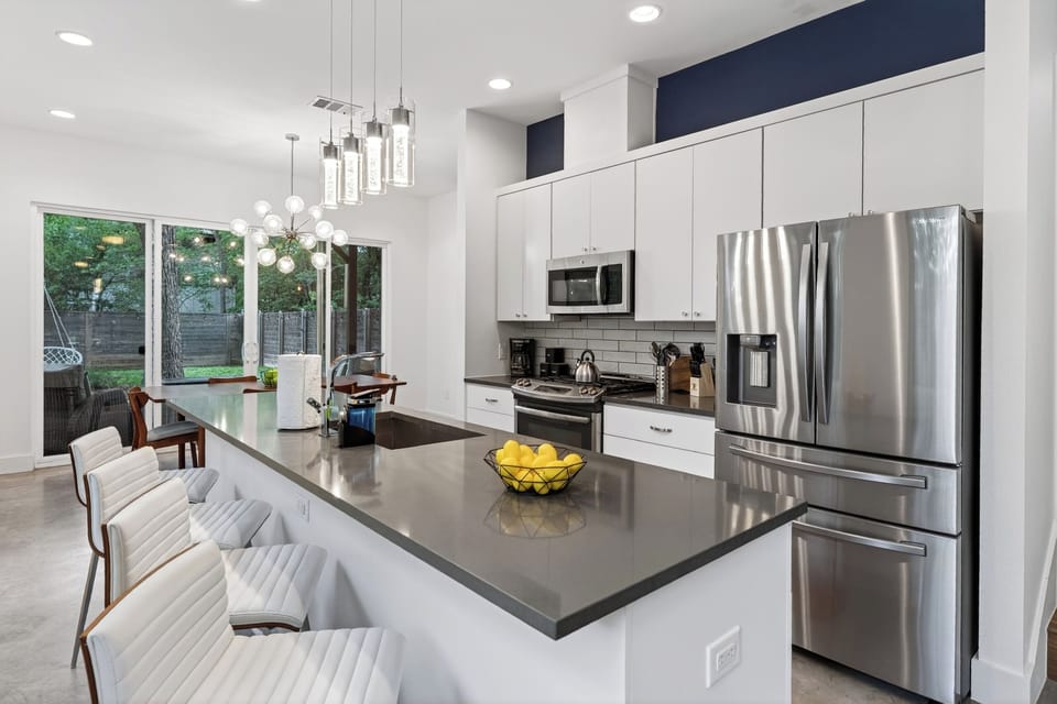 Modern kitchen with sleek finishes, large island seating, and stainless steel appliances for easy entertaining.